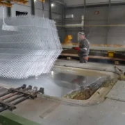 Гаряче цинкування на заводі і люди в робочій уніформі, що піднімають решітку-galery